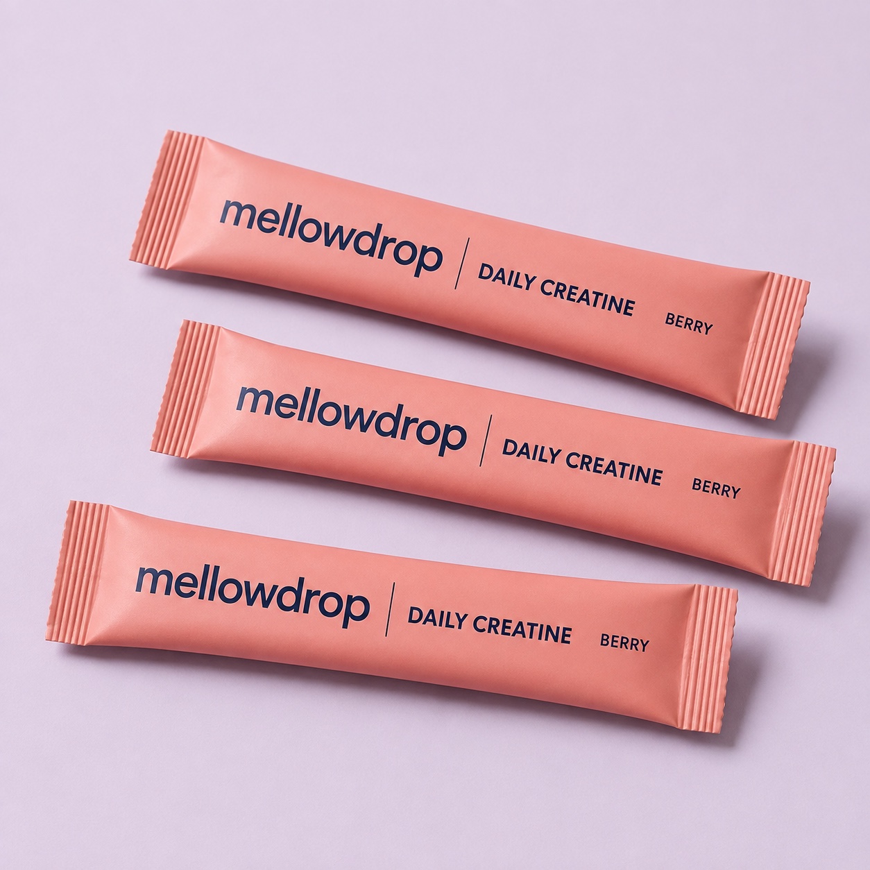 Three coral pink Mellowdrop berry creatine stick packs